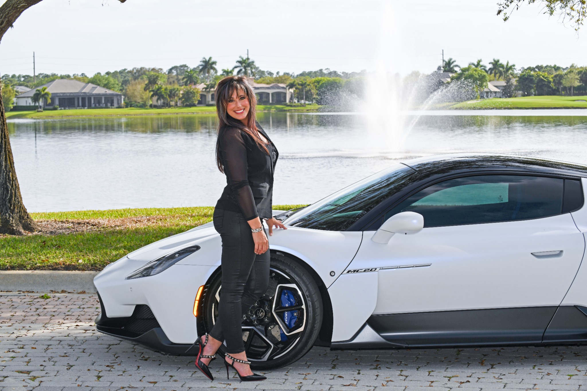 Luxury Real Estate Advisor Krysta Sylvester beside her Maserati with a fountain in the background